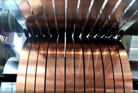 Steel strip passing through a precision slitting line producing narrow 6 mm strips